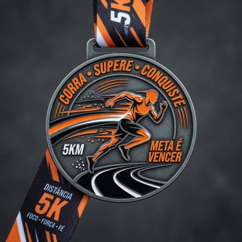 Sports medal with orange and black striped ribbon, featuring a runner silhouette and text reading Corra Supere Conquiste 5KM with Meta e Vencer